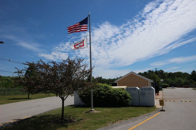 American flag at entrance to transfer station with outbuilding
